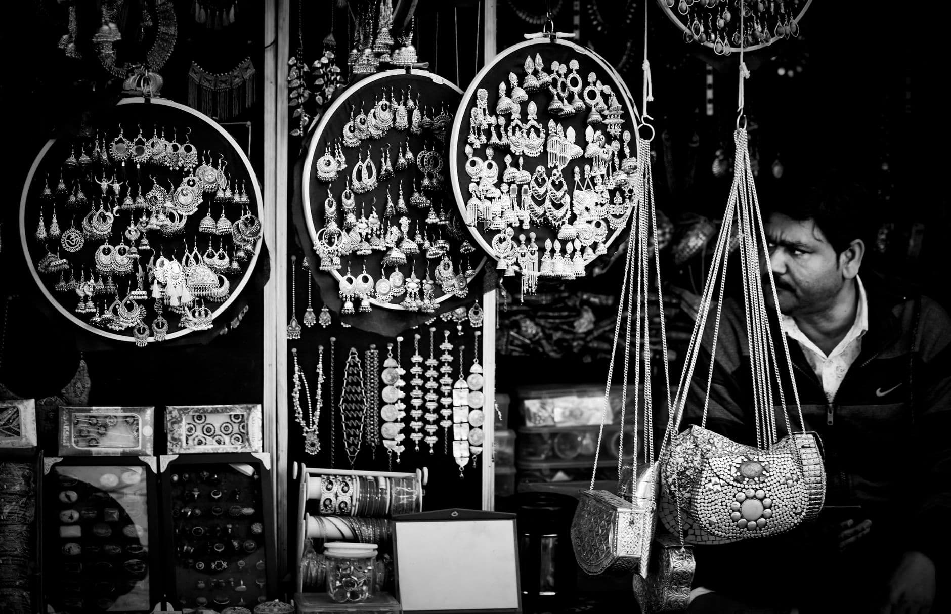 Elegantly arranged jewelry and accessories displayed at a street market in black and white.