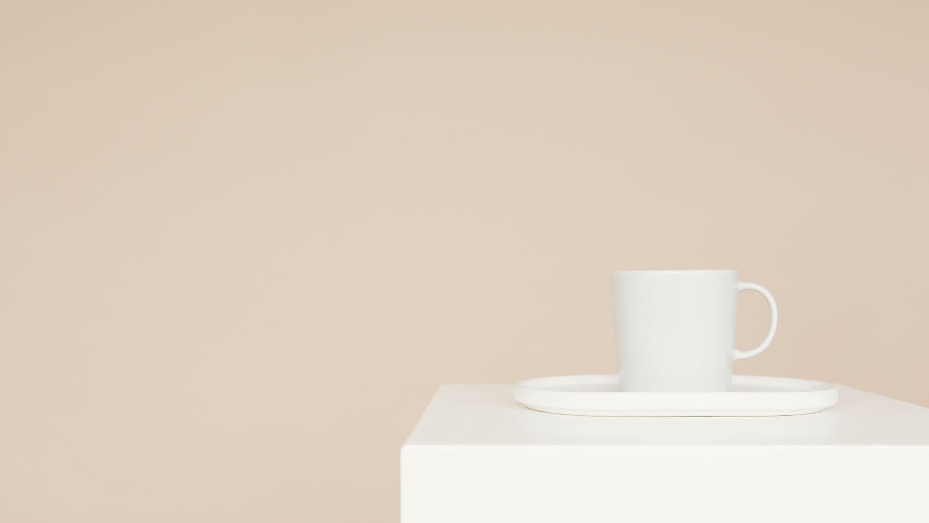 A white mug on a tray on a minimalist white block with a beige background, perfect for modern decor.