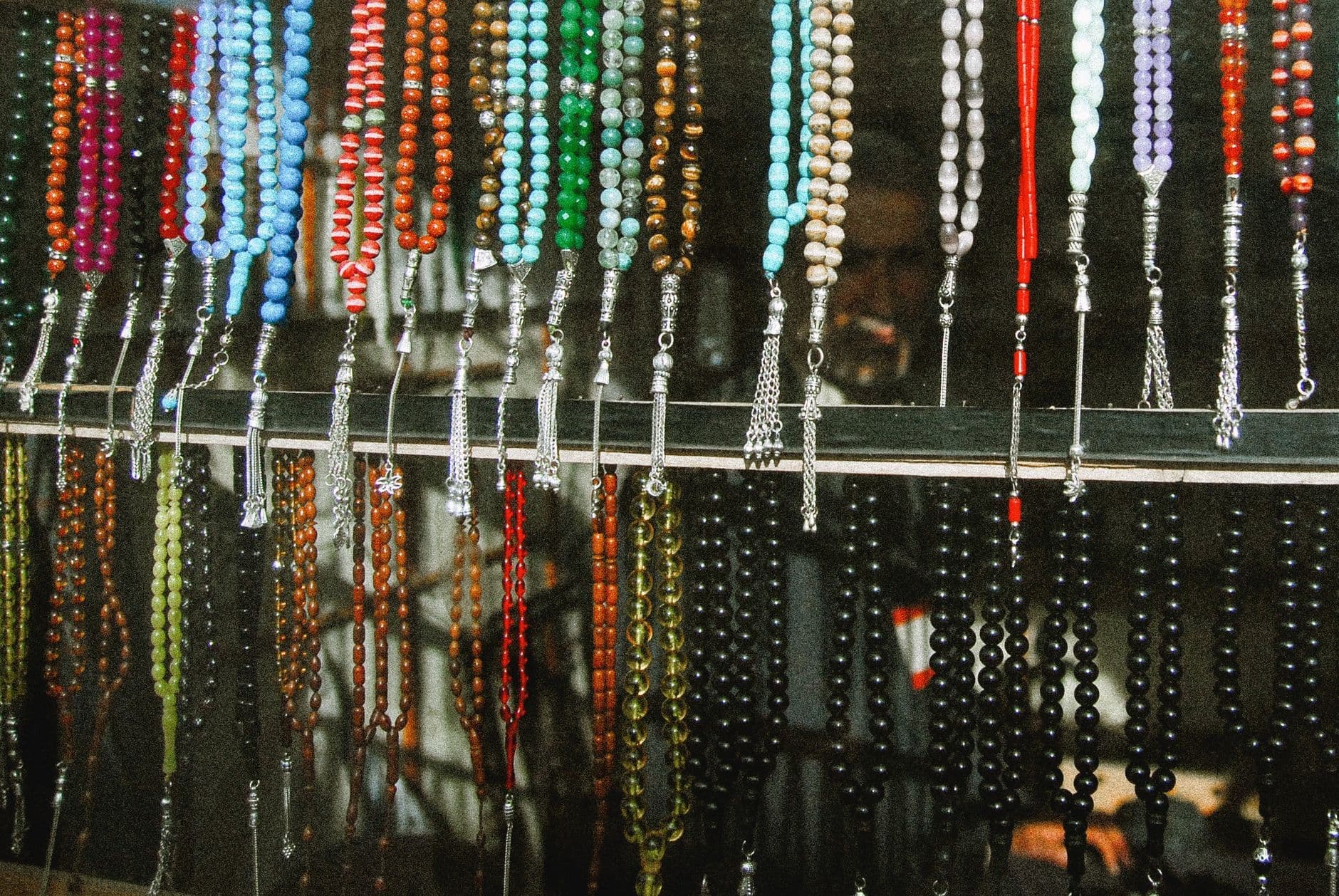 Vibrant assortment of prayer beads beautifully displayed in a traditional marketplace setting.