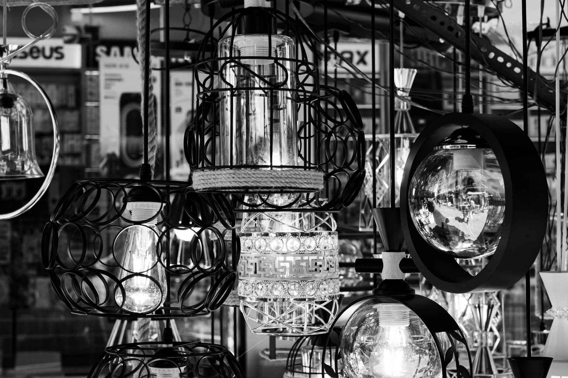 Artistic black and white shot of hanging lamps in a Colombo shop. Intricate designs and reflections create a captivating scene.