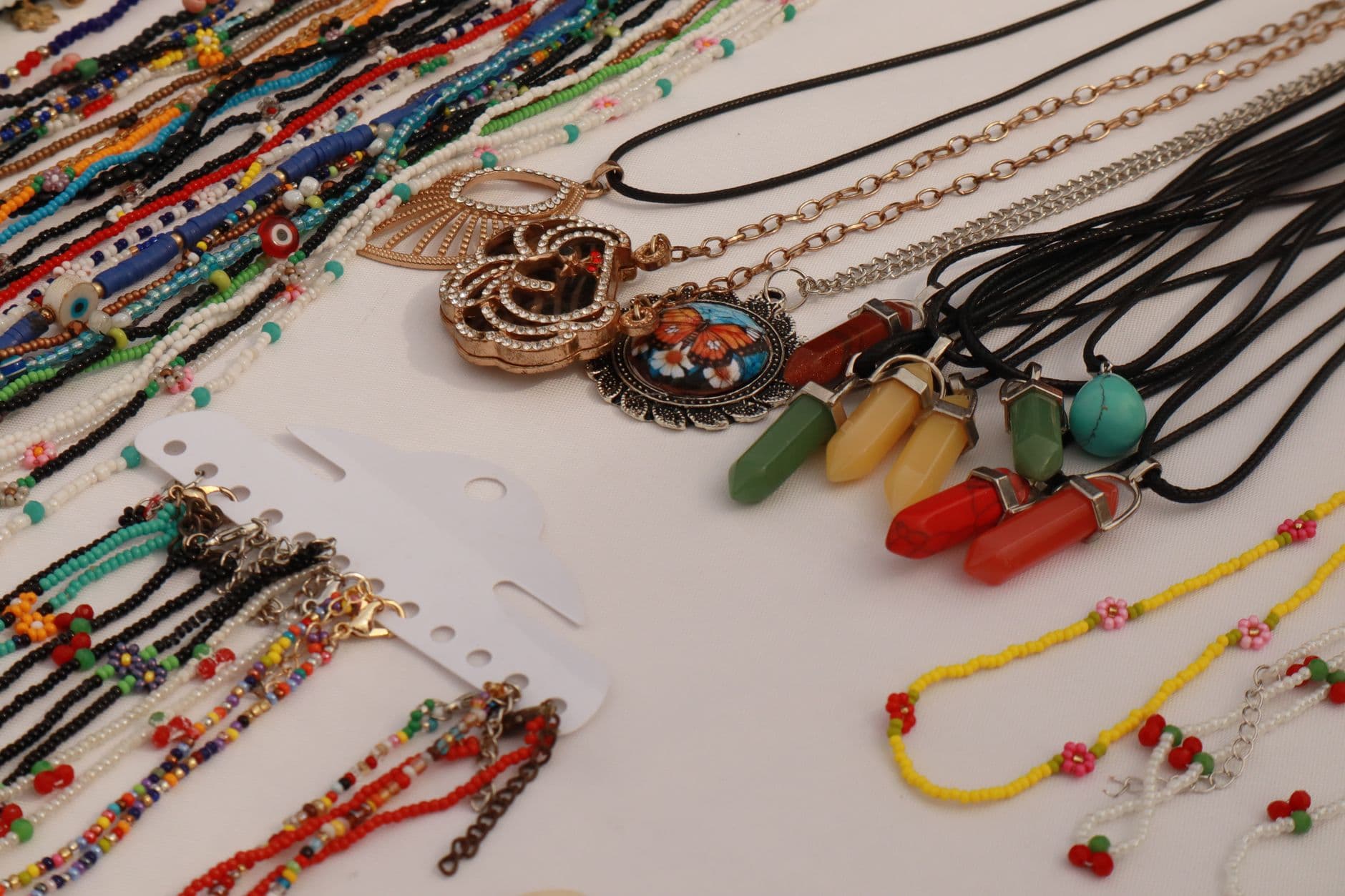 Variety of vibrant handmade beaded necklaces and pendants on display for sale.