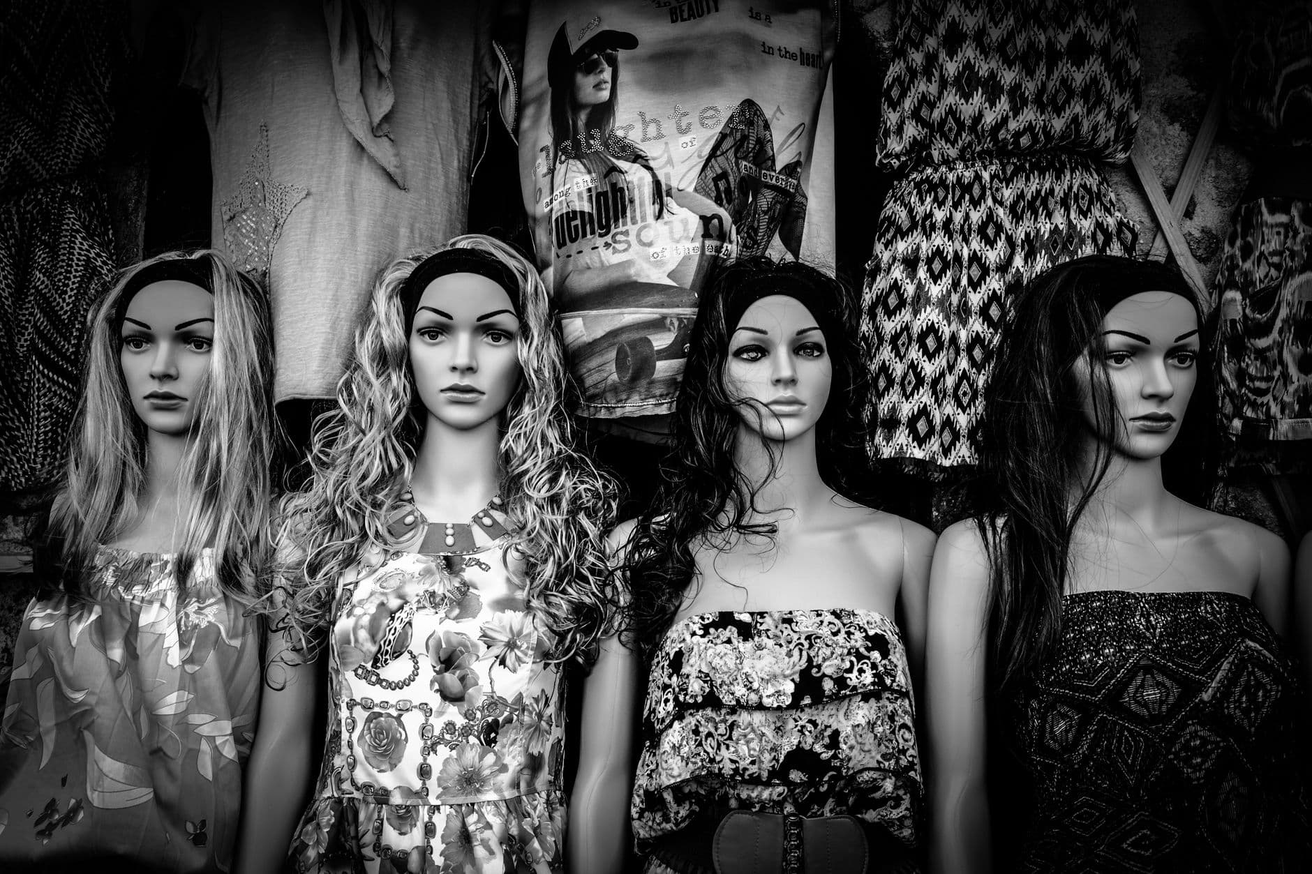 Stylish black and white display of mannequins wearing varied fashion dresses.